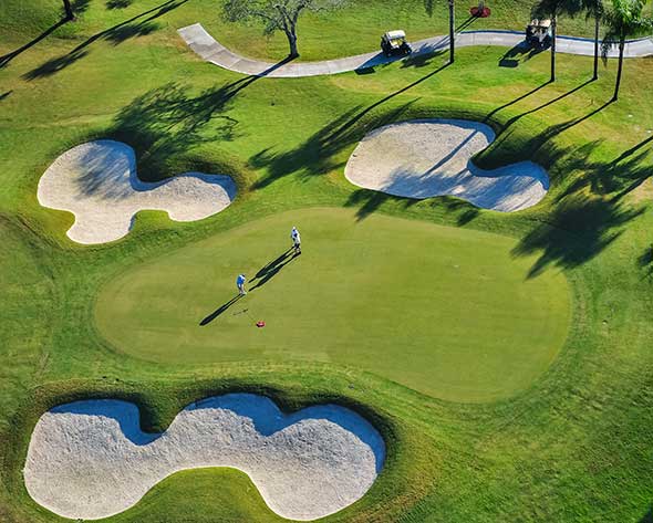 An overhead of a golf green with 2 people playing