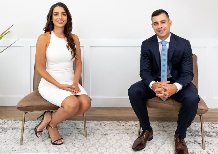 two real estate agents sitting in a living room.