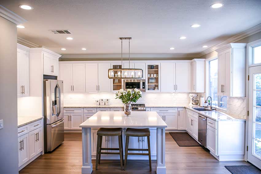 A very modern looking kitchen with white cabinetry and gold finishes