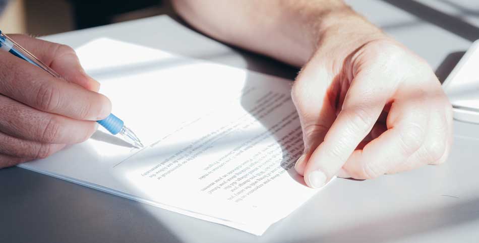 A picture of someone signing legal documents for the sale of their home.